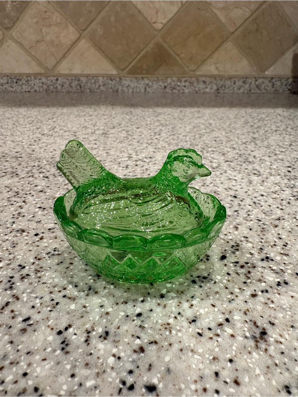 Vibrant green glass hen on a nest